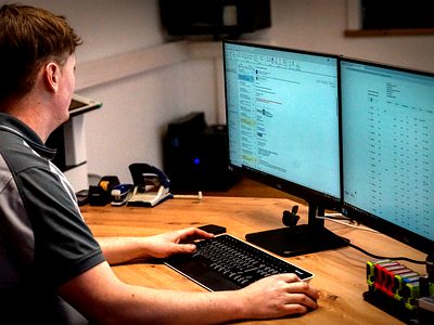 Mitarbeiter bei der Auftragsplanung am Computer – Bauer Zerspanungstechnik